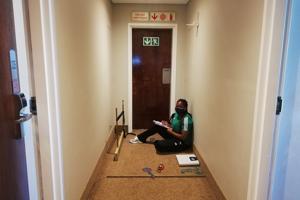 black woman sitting at the end of a corridor