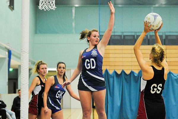 women playing netball in a gym