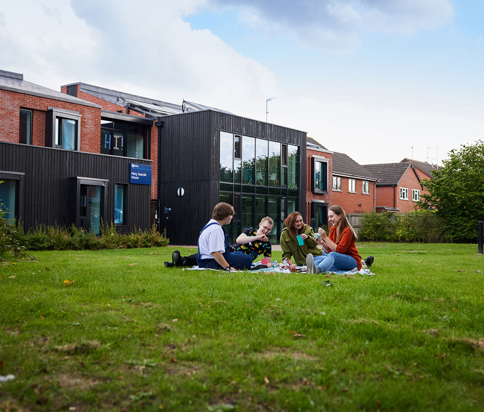 4 students are sitting in front of accommodation