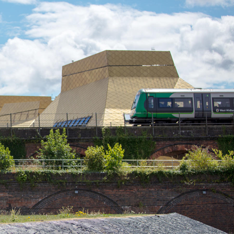 A train passing on the rail bridge beside the Hive library