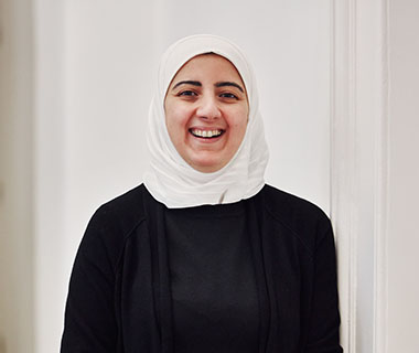 A smiling woman wearing a hijab