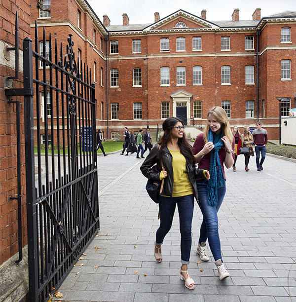 2 women walking out of University of Worcester City Campus gates