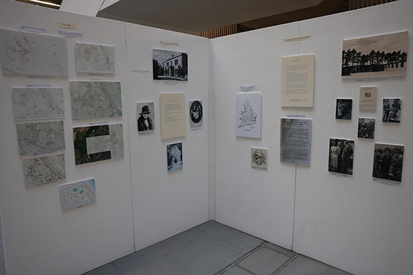 Old images of the University and maps are displayed on a white board. The images show a variety of people and locations with text boxes giving information as part of an exhibition display.