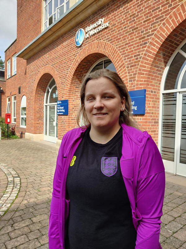 Person standing in front of building facing camera