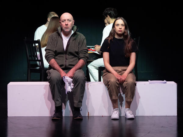 Two people on stage sat next to each other facing forwards