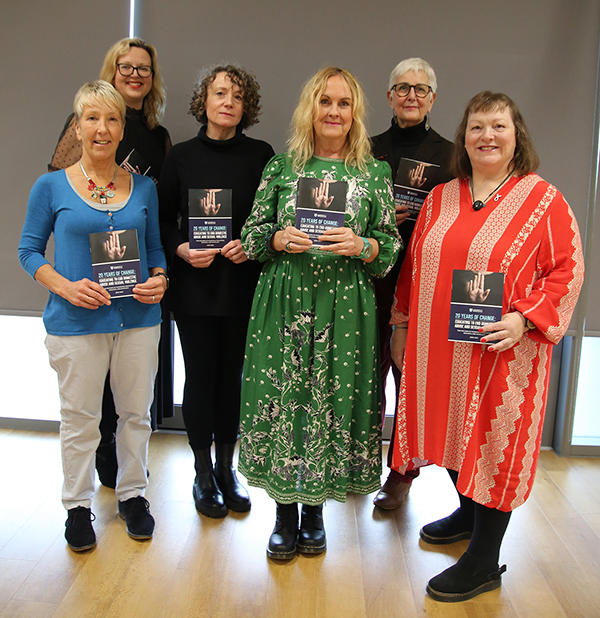A group of people, who were all speakers at an event to mark 20 years of groundbreaking work at the University of Worcester in tackling domestic abuse and sexual violence through education, research, and advocacy. They are all standing holding a leaflet w