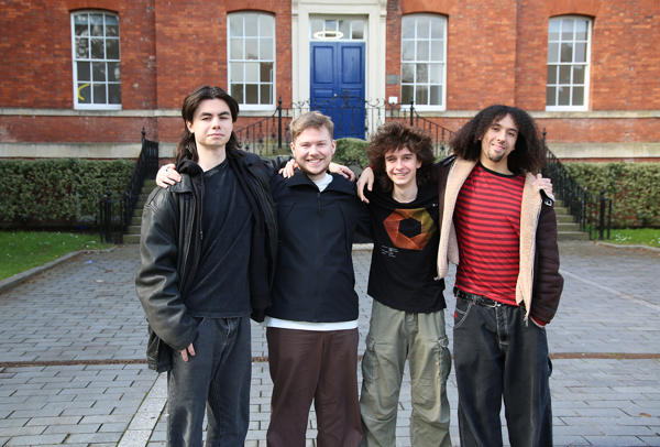 Group of four people gathered together outside a building