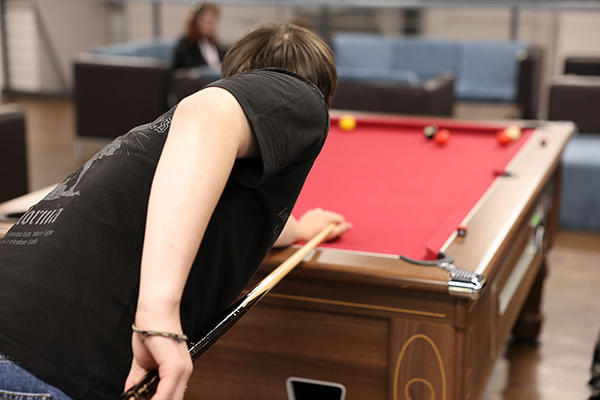 Person playing pool at pool table