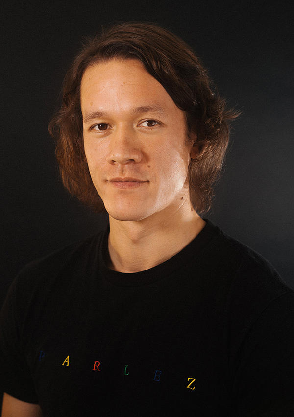 Ben Newell dressed in a black t-shirt looking at the camera