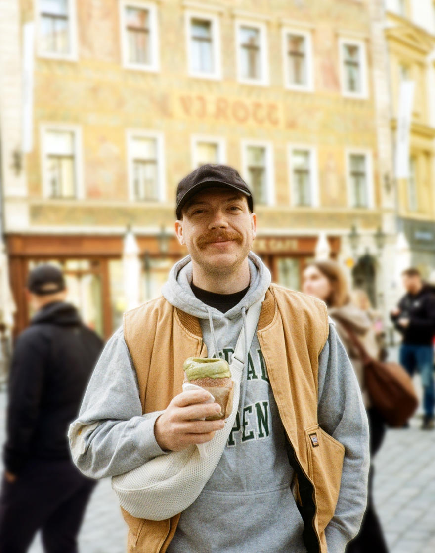 Matt Searle stands looking at the camera with a cup in his hand