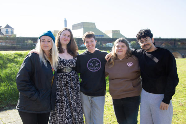 Group of five people gathered together facing camera