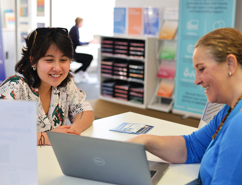 A student speaks to a member of support staff