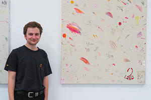Cameron Bryan standing next to his work