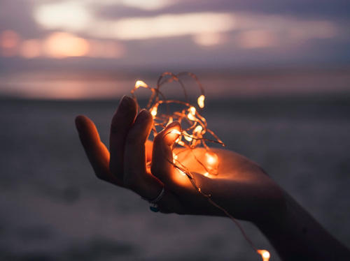 An image of someone's hands with lights inside them