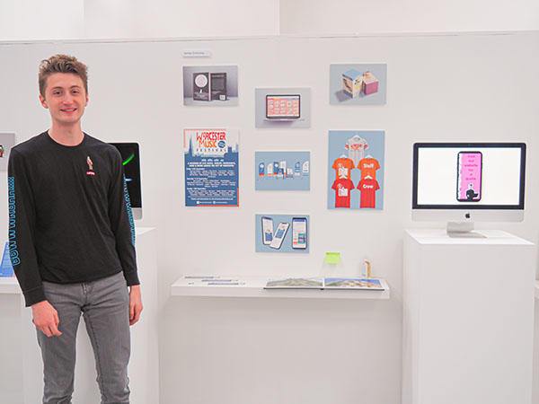 James Critchley stands next to his work