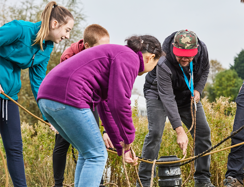 Students in warm clothing outside holding a rope- team building activity