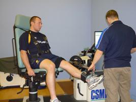 A sports science student checks an athlete's ankle