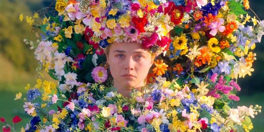 A girl is covered in many brightly coloured flowers