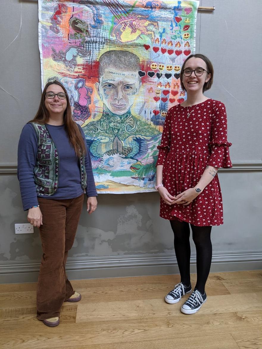 Lecturer Ruth Stacy and a Student stand in front of an artwork