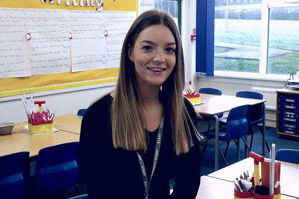 An education student smiles in a school classroom