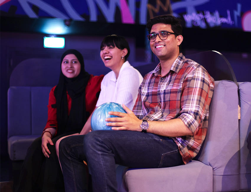 Students sat laughing and watching someone bowl off camera