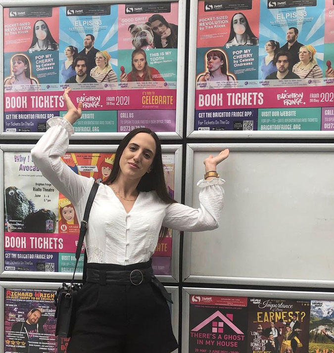 Student Tisa Klicek in front of some show posters at Brighton Festival