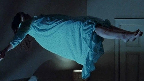 A girl is levitating above a bed in this film still