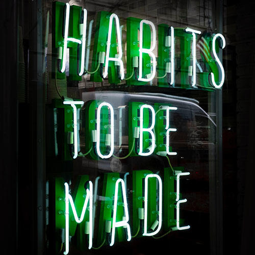 The Words "Habits to be Made" lit up in neon"
