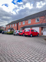 View of Fern House on a partly cloudy day with cars parked outside