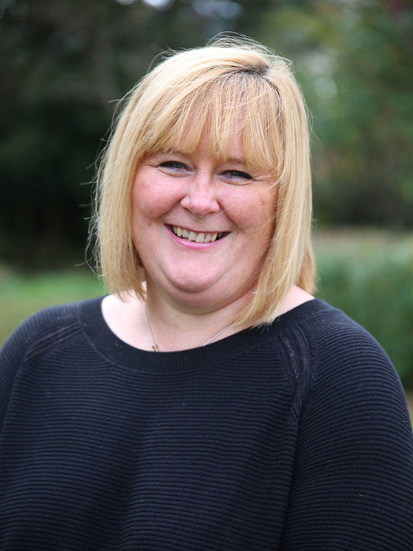 Annabel Collins smiling against a green background