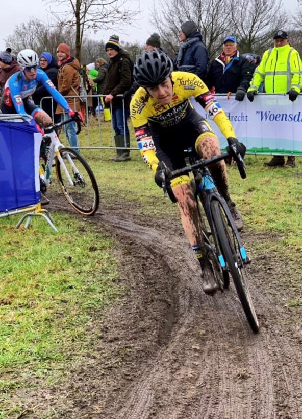 Beth Crumpton cycling on a dirt track wearing a yellow helmet.