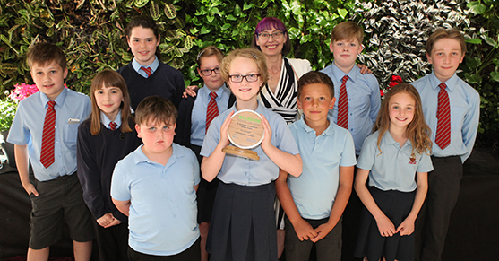 A group of school children holding a community award