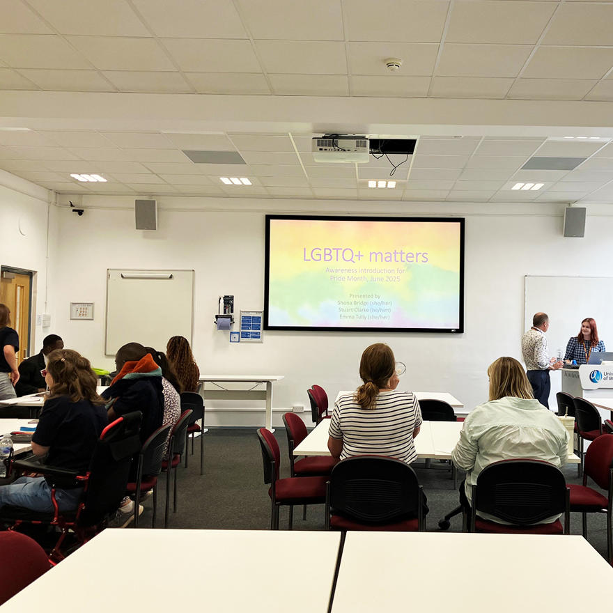 Staff in a classroom looking at an LGBTQ+ matters presentation