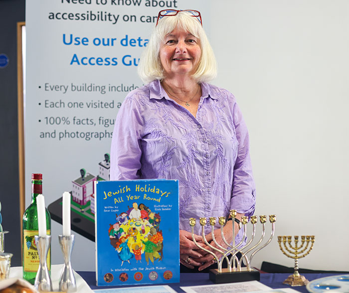 A lady is standing behind a menorah