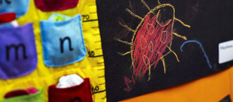 A close up shot of some educational wall hangings. They are bright yellow, black and red and feature insects and letters.