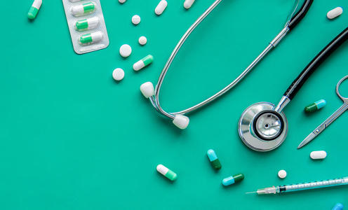 Pills and medical equipment on green background