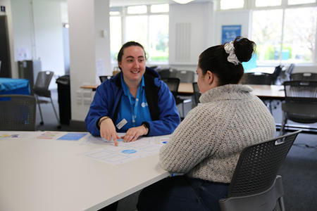 Two students sitting at a table talking