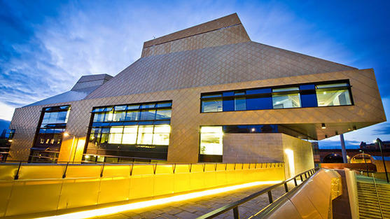 The Hive exterior appears very golden against a dramatic dark blue sky