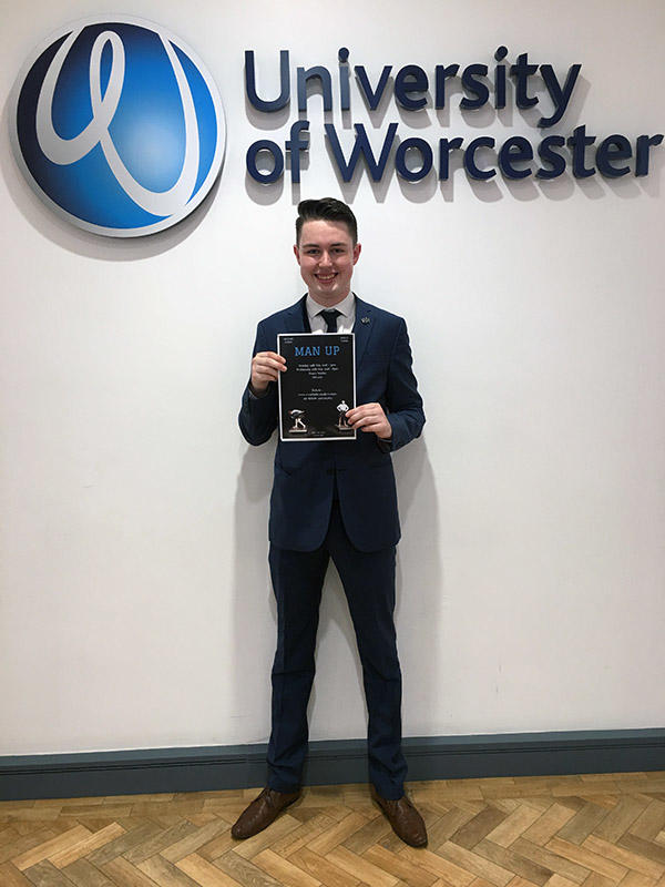 Jordan Smith is wearing a suit and showing his graduation certificate. The University of Worcester logo is in the background