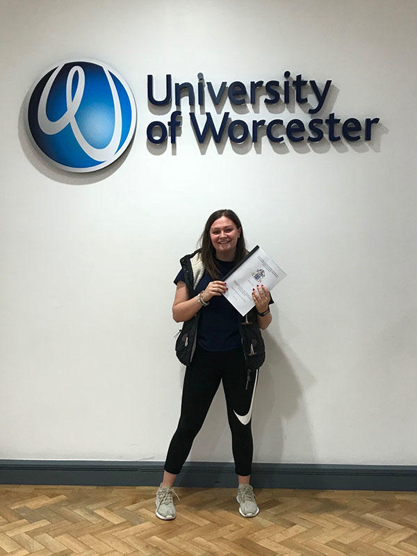 Kelly Gates is holding a certificate against a University of Worcester background