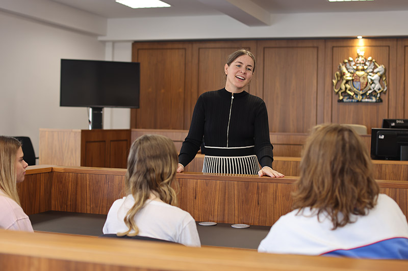 A lecturer talks to students in the University of Worcester mock law court