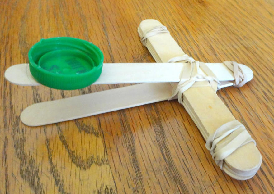 a lollipop catapult on a wooden table