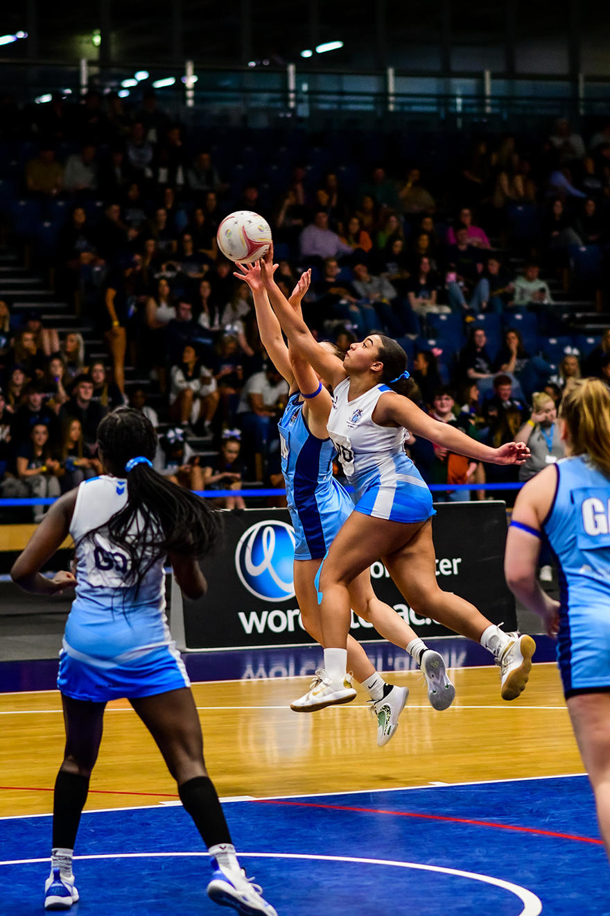Netball payer jumping in the air to catch a netball