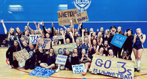 UoW Netball team at varsity holding up signs