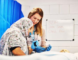 nursing student with lecturer checking a patient in a simulated ward