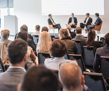 A group of business people are watching a discussion