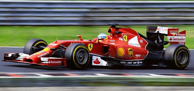 A man driving a red formula 1 car