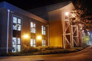 The outside of a sports centre lit up at night