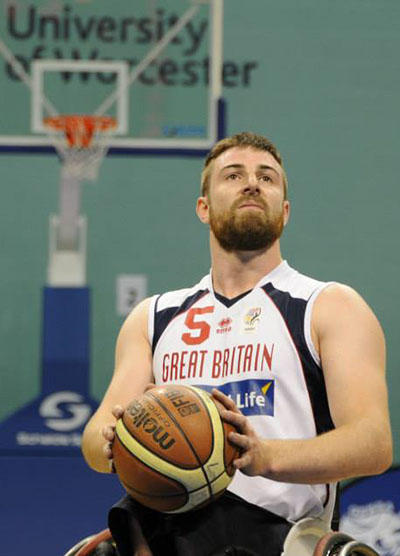 A Great British wheelchair basketball star holds a basketball