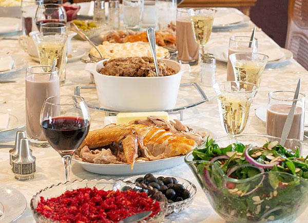 A table top is full of thanksgiving dinner including turkey, cranberry sauces and salads